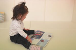 保育園で絵本を読む女の子